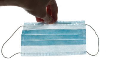 Mavi tıbbi maske. Kauçuk kulaklıklı cerrahi maske. Ağız ve burnu örtmek için tipik 3 katlı cerrahi maske. Bakterilerin prosedür maskesi. Koronavirüse karşı koruma konsepti. El maskesi.