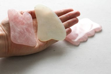 Yüz ve vücut masajı. Dişi el, doğal taş mineral gül kuvarstan yapılmış gouacha 'yı avucunda tutar. Güzellik, yüz ve vücut gençliği için terapi masajı. Metnin için boşluk kopyala.