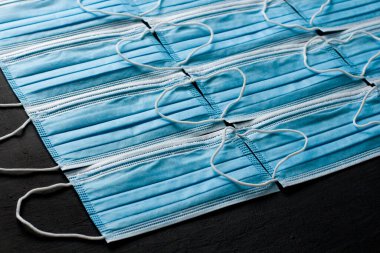 Mavi tıbbi maske. Kauçuk kulaklıklı cerrahi maske. Ağız ve burnu örtmek için tipik 3 katlı cerrahi maske. Bakterilerin prosedür maskesi. Koronavirüse karşı koruma konsepti. Arkaplan maskesi.