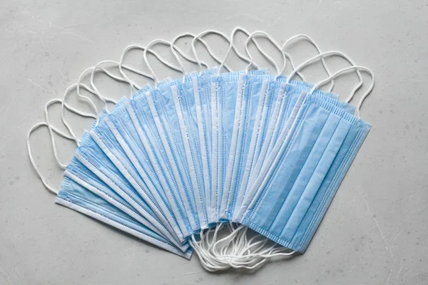 Blue Medical disposable masks for protection lie on white background. Surgical used mask. Typical surgical mask to cover mouth, nose. Procedure mask bacteria. Protection concept, against coronavirus.