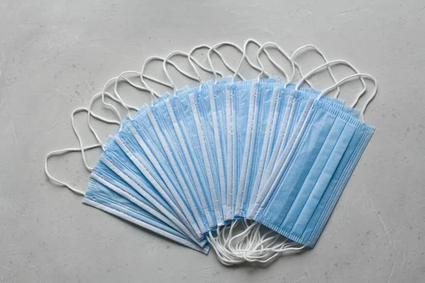 Blue Medical disposable masks for protection lie on white background. Surgical used mask. Typical surgical mask to cover mouth, nose. Procedure mask bacteria. Protection concept, against coronavirus.