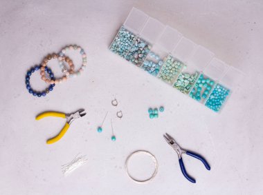 El yapımı mücevherler. Üst Manzara. Boncuklar, mücevher yapmak için aletler. El yapımı için hazırlık. Doğal taşlardan kendi ellerinle mücevher ve bilezikler yarat. Düz yatıyordu. Beyaz arkaplanda.