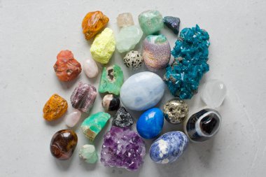 Dünyanın dört bir yanından gelen çok renkli doğal taş ve minerallerin güzel bir koleksiyonu beyaz arka planda yatıyor. Amber, Carnelian, Pyrite, ametist, zümrüt, agate. Güzel taşlar ve mineraller.
