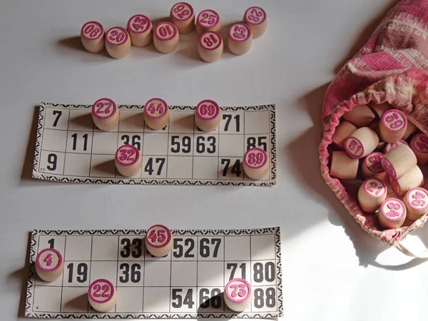Russian lotto, bingo board game, barrels and cards on a white background. Quarantine Games Concept. Board game lotto with wooden barrels. Money game, luck, luck, excitement, board games, stay home.