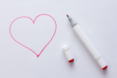 Parlak kırmızı bir keçeli kalemle ya da beyaz bir arka planda kırmızı bir kalple çizilmiş. Aşk, romantizm, sevgililer günü. Basit çizim, kalp..