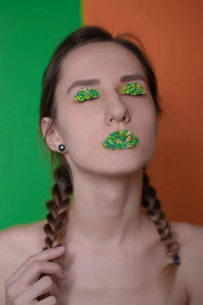 Retrato de mujer joven con maquillaje de caramelo: perlas multicolores en los labios y párpados — Foto de Stock