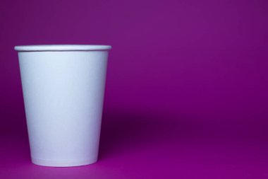 Pembe arka planda boş beyaz bir kağıt bardak.