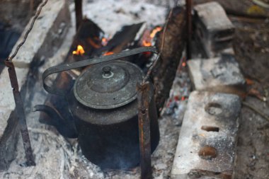 Kamp ateşinde eski bir dökme demir çaydanlık