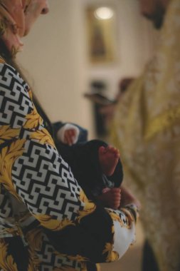 Yeni doğmuş bir bebeği kucağına alan bir kadının küçük bacakları.