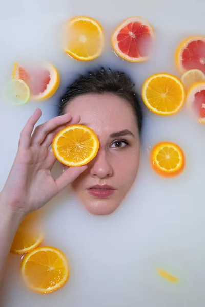 用橙子、柠檬和柚子洗澡时的妇女画像。时装模特、温泉及护肤概念. — 图库照片