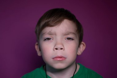  Pembe arka planda dokuz yaşında üzgün, sarışın bir çocuğun portresi.