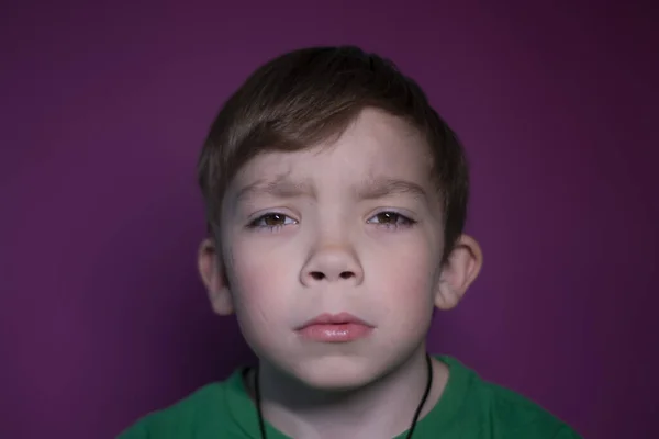 Portrét zamyšleného smutného devítiletého blonďáka na růžovém pozadí — Stock fotografie