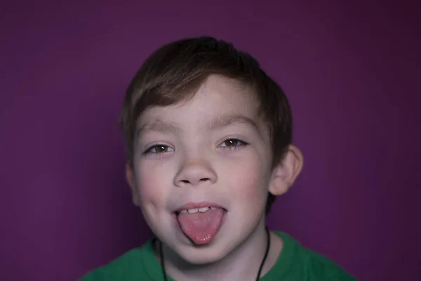 Retrato de um menino loiro de nove anos em um fundo rosa — Fotografia de Stock