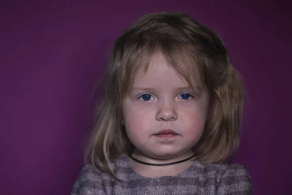 Retrato de una niña rubia de tres años con ojos azules sobre un fondo rosa —  Fotos de Stock