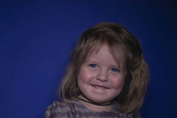 파란 배경에 파란 눈을 가진 행복 한 세 살짜리 금발 소녀의 사진 — 스톡 사진