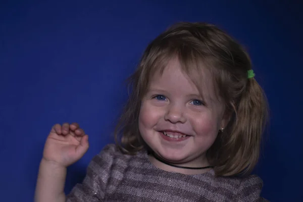 파란 배경에 파란 눈을 가진 행복 한 세 살짜리 금발 소녀의 사진 — 스톡 사진