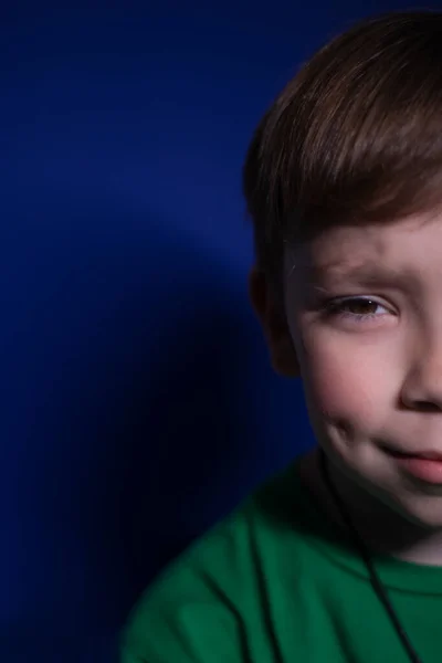 Retrato recortado de un niño rubio de nueve años sobre un fondo azul — Foto de Stock