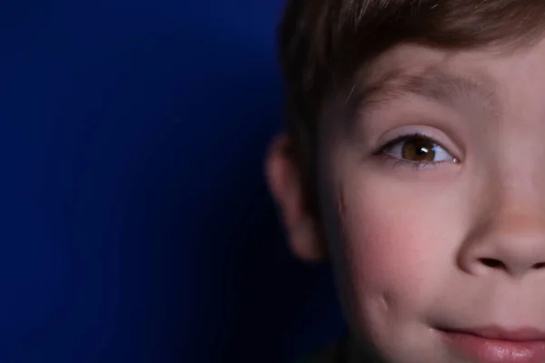Portrét šťastného devítiletého blonďáka na modrém pozadí — Stock fotografie