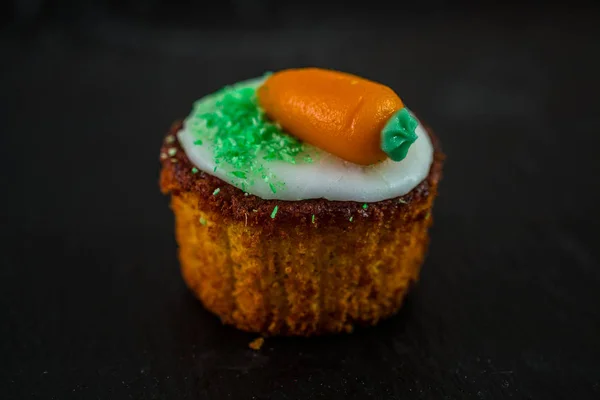 Small round carrot cake on black background