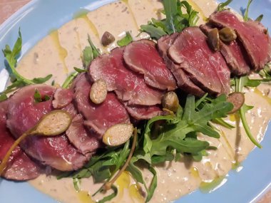 Vitello tonto, mavi tabakta salata ile servis edilir.