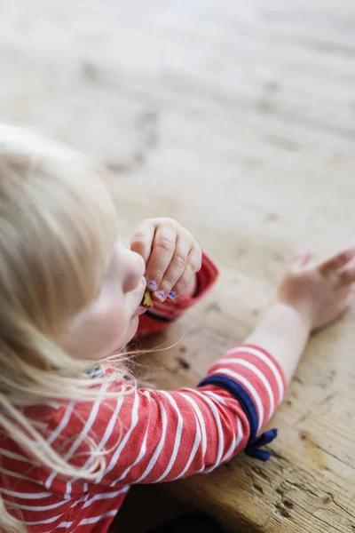 Chica comiendo galleta mientras está sentado — Foto de Stock