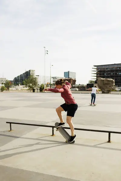 Žena, která dělá skate trik v parku — Stock fotografie