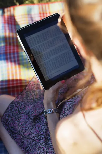 Woman holding e-reader in park — Stock Photo, Image
