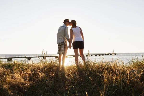 Man en vrouw kussen op strand — Stockfoto