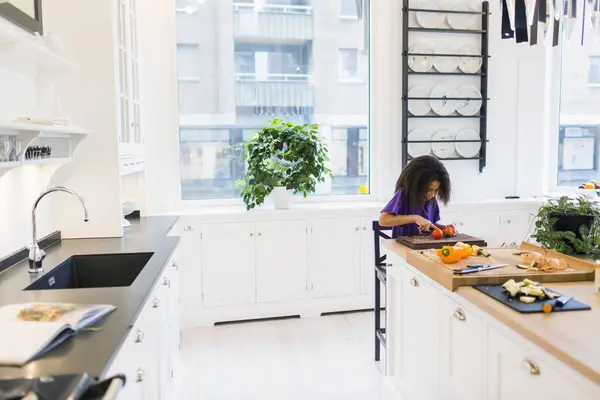 Κορίτσι σε φέτες ντομάτες στην κουζίνα — Φωτογραφία Αρχείου