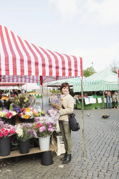 Mogen kvinna att köpa bukett — Stockfoto