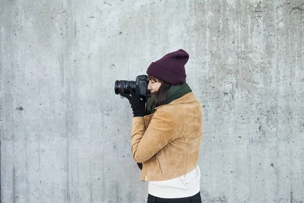 Woman photographing against wall — Stock Photo, Image