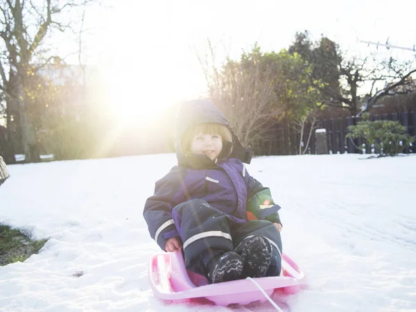 Happy girl sledding on snow — Stock Photo, Image