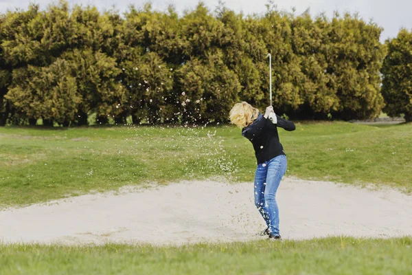 Vrouw die golf speelt op het veld — Stockfoto