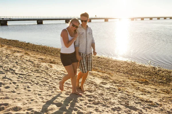 Pareja joven caminando en la playa — Foto de Stock