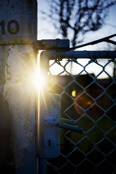 Zonlicht streaming via metalen poort — Stockfoto
