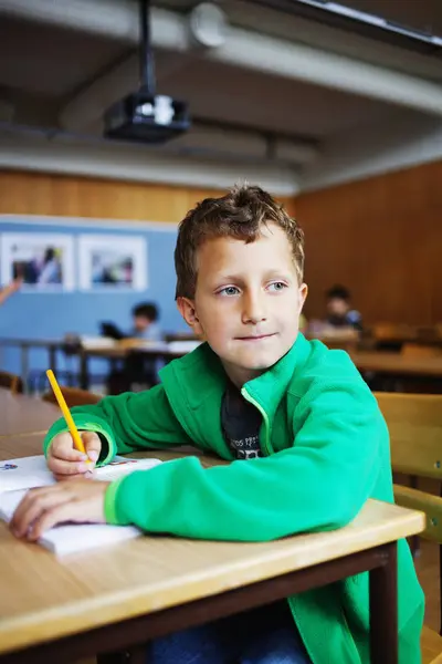 Gutt sitter ved skrivebordet – stockfoto