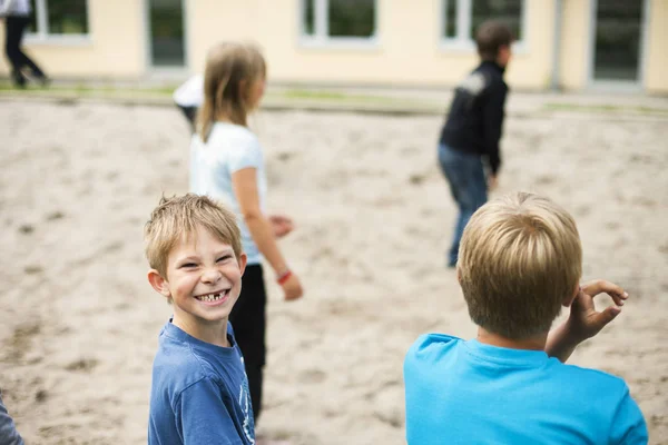 Skolpojke spela med vänner vid lekplatsen — Stockfoto