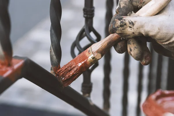 Painting forged railings on the stairs at the entrance of the house. Protection against rust. — Stock Photo, Image