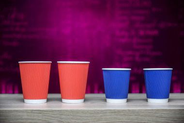 Dört tek seferlik kağıt bardak kahve, ahşap bar boşluk, merkezi ve kopya vurgulama ile sayaç, karanlık yumuşak arka plan için tasarım şablonu