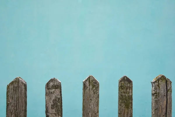 Старый деревянный забор, стена побелена известью в цвет морской волны на заднем плане, место для текста — стоковое фото