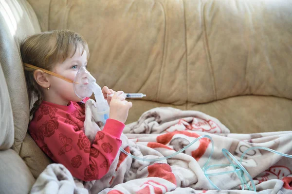 Little girl in a mask, cough treatment using a nebulizer at home — Stock Photo, Image