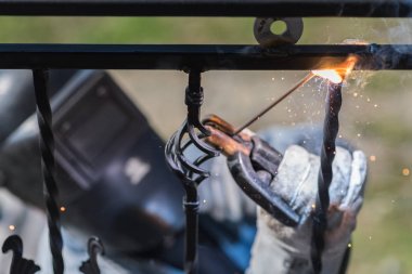 Metal korkuluk merdiven üzerinde kaynak işçisi