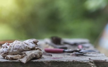 Eski ahşap bir masadaki aletler, bahçede ve evde çalışıyor.