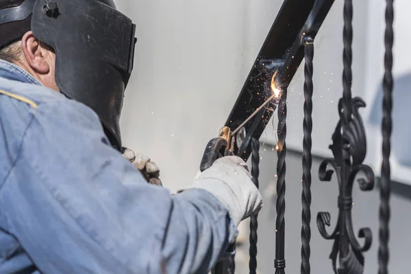 Kaynakçı açık merdivenler, sahte öğeleri, iş akışı, işlem metal Küpeşte kaynak. Ev ve dış.
