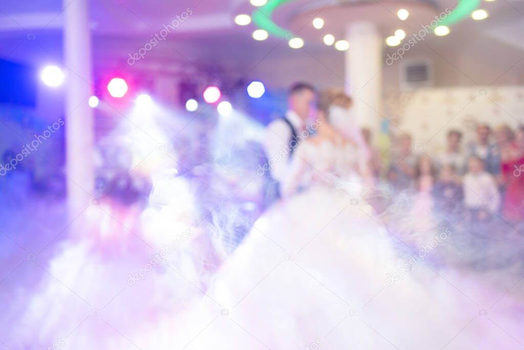Abstract colorful blurry background, copyspace for text. Newlyweds dance their first dance. Dance is decorated with light effects and smoke. Shows organization services.
