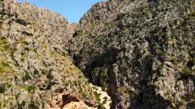 Yüksek kayalık dağlar arasındaki dar yol, vadi. Sa Calobra resim gibi ve Mayorka 'da popüler bir turizm merkezi. Hava aracı 4K sinematik görüntüler