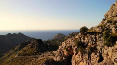 Dağlık arazi. Kayalıklar. Güzel bir yaz gününde gün batımı zamanı. Mayorka, Balear Adaları. Turizm, yürüyüş, açık hava aktiviteleri. Mayorka 'nın (Mallorca) güzel doğası, Balear Adaları, İspanya. Drone 4K UHD sinematik görüntüler