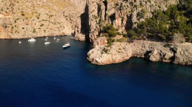 Kayalık bir koyda yatlar. Picturesque Sa Calobra liman köyü, Escorca, Mayorka, Balearic Adaları. Majorca Adası 'ndaki popüler turizm merkezleri. İHA 4k sinematik görüntüler