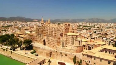 Palma şehrinin Santa Maria Katedrali, Mayorka. Güzel mimarisi olan havadan şehir manzarası, güneşli bir yaz günü. Palma de Mallorca 'daki popüler turizm merkezleri. Hava aracı 4k sinematik görüntüler