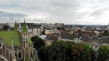 Lviv 'in şehri. Güvercinler eski kilisenin yakınında uçar. Lviv şehrinin simgeleri ve mimarisi. Popüler turistik yerler. Hava Aracı 4K Sinematik Görüntüler